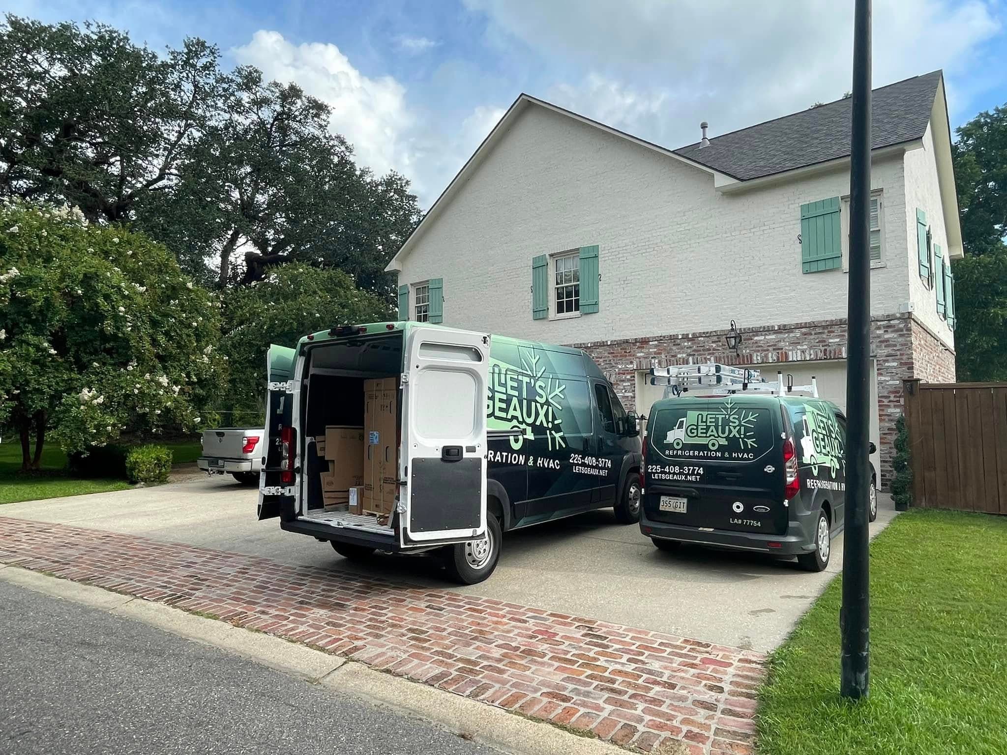 Let's Geaux service vans at a residential home